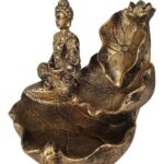 O incensário buda meditando trás para seu ambiente a elegância desta peça na cor bronze, com toque de leveza e harmonia. Ideal para criar uma atmosfera serena e espiritual em qualquer ambiente, este incensário é perfeito para meditação, práticas religiosas ou simplesmente como um belo objeto decorativo. Especificações: – Porta Incenso Buda Meditando. – Material: Resina. Dimensões (A x L x P): – 14 x 10 x 12 cm.